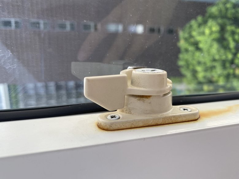 Rusted window latch documented at move-in, pre-existing condition on record
